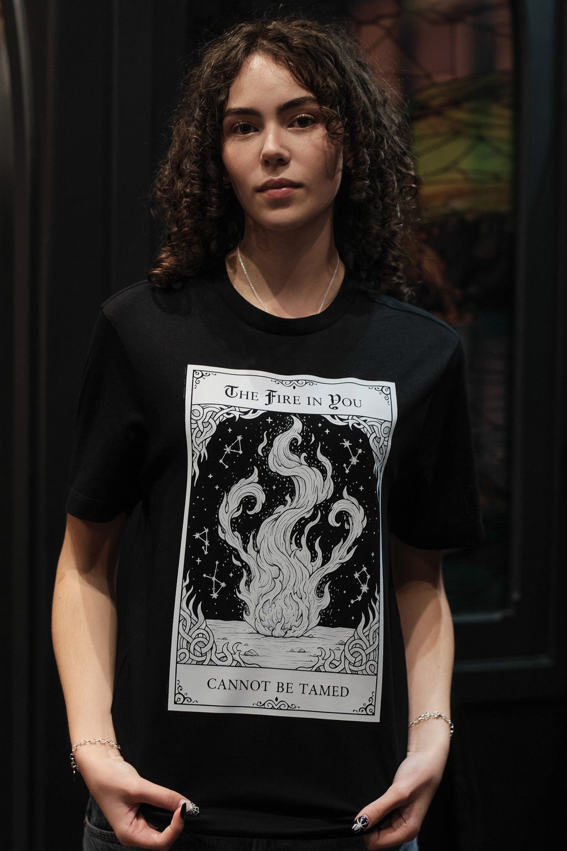 Person wearing a black t-shirt with a graphic design and text.